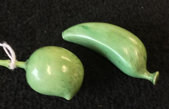 Two green-stained ivory carvings of fruit, peach and banana